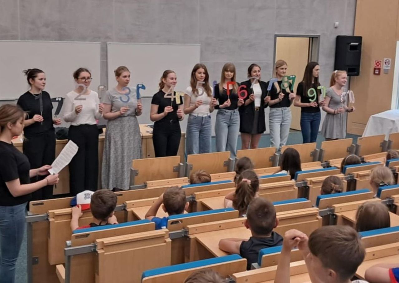 Studenci na auli razem z dziećmi