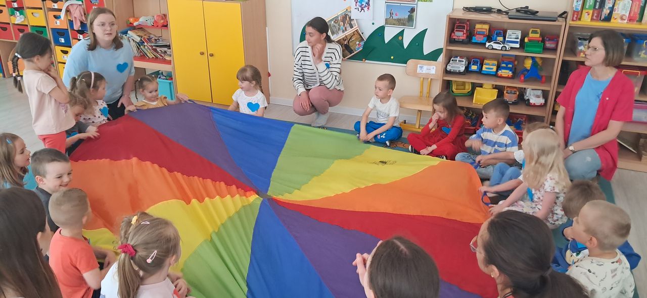 Zabawa dzieci i studentów z chustą animacyjną